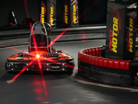 Kart electric CRG în viraj pe circuitul indoor Red Motor, lângă bannerele circuitului