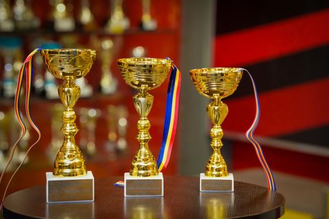 Trei cupe aurii cu panglici tricolore, pregătite pentru premiere la Red Motor