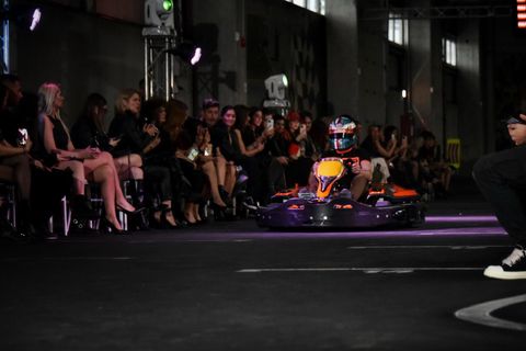 Prezentare de modă pe circuitul Red Motor, cu un kart defilând prin fața publicului